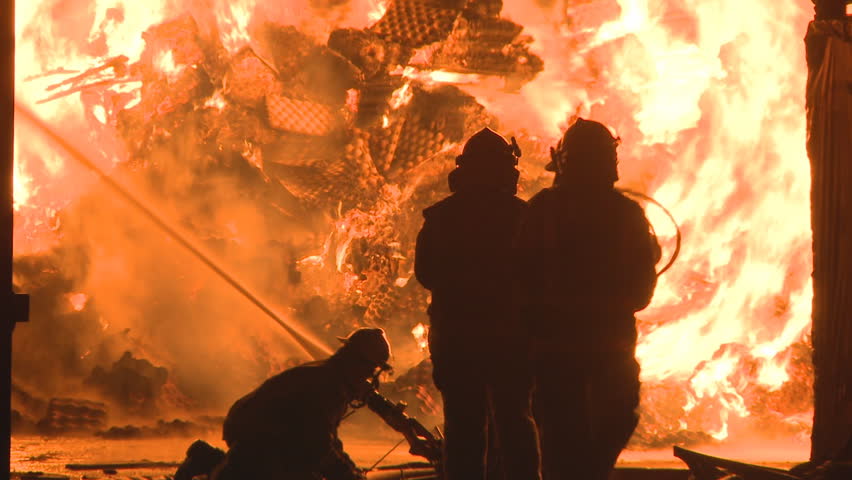 Firemen at a huge fire at an industrial site.