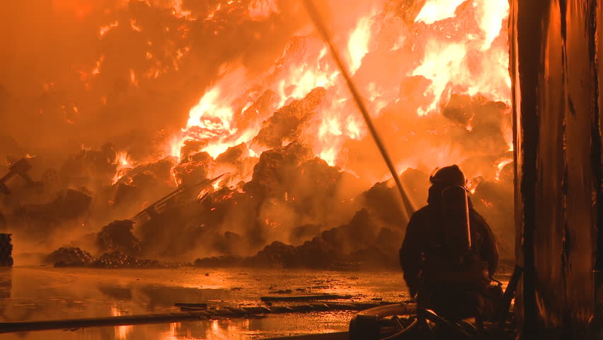 A fireman fights a large night time fire