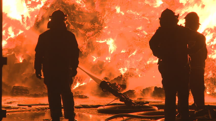 Firemen silhouetted at a large fire