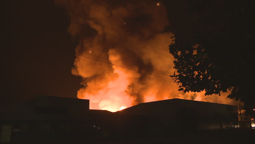 Smoke and flames rise high into the night air at a large industrial fire