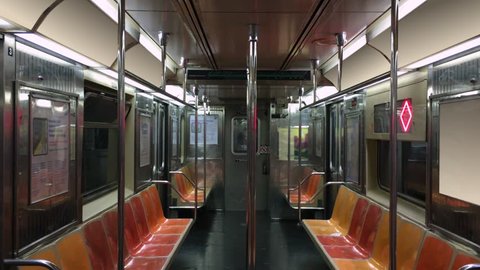 An interior establishing shot of an empty New York City subway car as it travels along the tracks. Loopable.  No passengers, perhaps during a pandemic like COVID-19 or Coronavirus.	