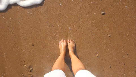 feet in the sand on the beach