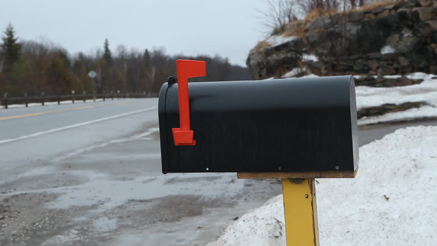 Mailbox on rural winter road. Car goes by. Ontario, Canada.
