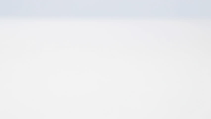 Planting seeds falling on white table 4K. Dolly sliding over white table with small seeds flying all around.