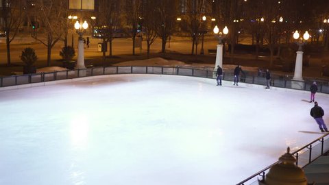 CHICAGO, IL - JANUARY 17 - People skating at ice rink in downtown Chicago, Illinois Millennium park on ice cold freezing winter's night of January 17, 2016.
