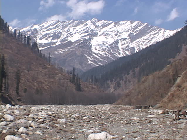 A man rides his horse across a rocky field.