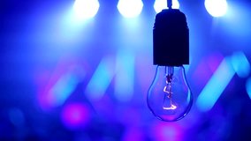incandescent lamp against the background of concert, dance music, lighting effects, light bulb closeup
