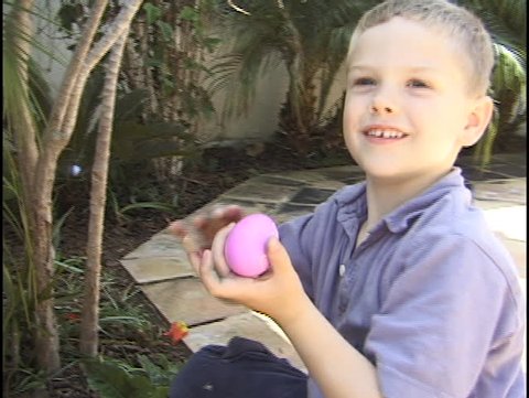 A young boy hunts for Easter eggs. Stock Video