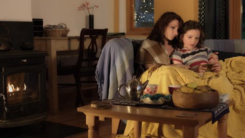 4k Shot in Warm and Cozy Atmosphere of a Woman with her Son looking at Fireplace