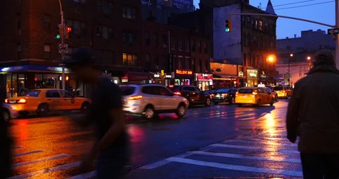 NEW YORK CITY - CIRCA MAY 2015: Street view of people walking and traffic in Manhattan at dusk while raining.            