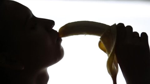 Close-up of Young amazed woman holding a banana, she is going to eat a banana. she sucks a banana