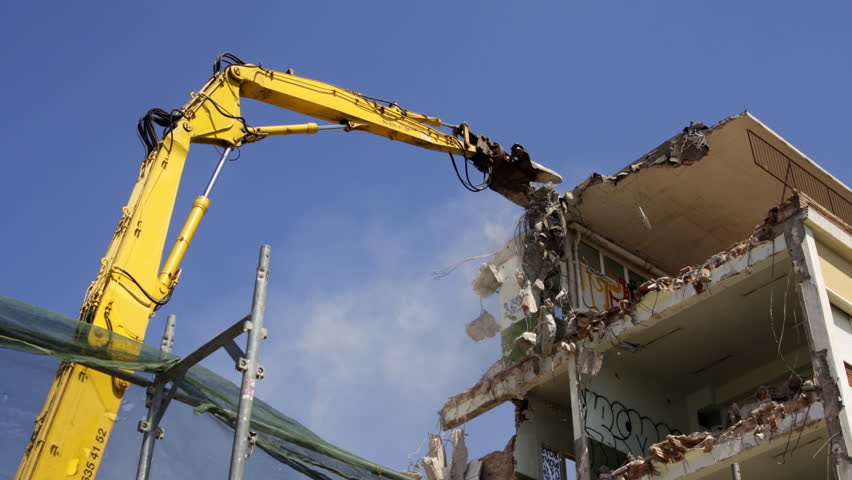 a crane breaking down a building, looking a bit like like a dinosaur eating!