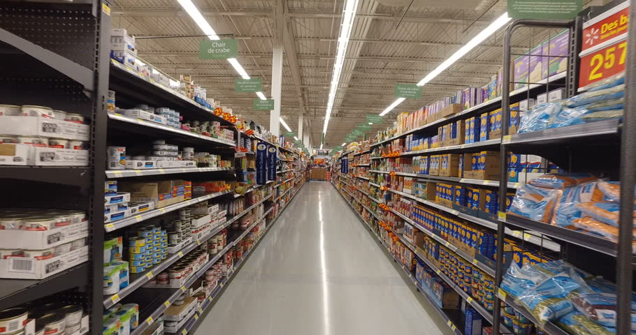 MONTREAL, CANADA - AUGUST 2016: Shopping Inside Walmart - Professional Steadicam Shot (Aisle with canned food, dry snacks, baking flour etc.)