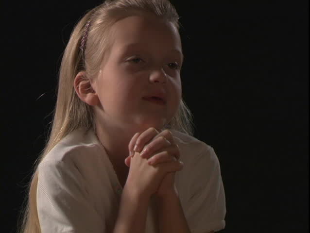 A young girl prays.