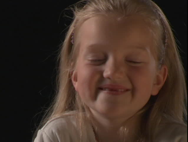 A young girl smiles and makes silly faces.