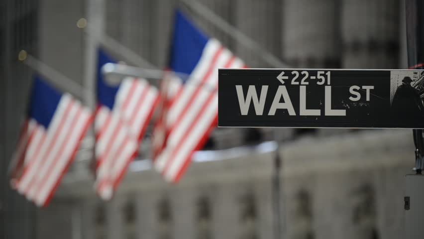 Wall Street sign with American flags purposely blurred in background, HD video
