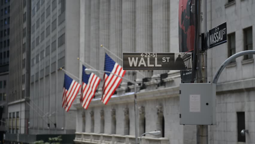 Wall Street sign with American flags purposely blurred in background, HD video