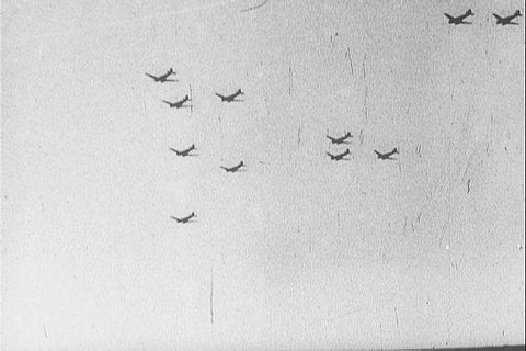 Troop carrier aircraft drop paratroopers over Europe despite bad weather and poor visibility, during World War II. (1940s)