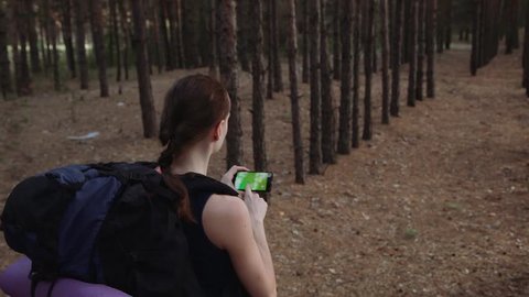 Woman tourist with backpack using navigation app on smartphone in the beautiful wild forest. Travel concept. Green screen change ready. Stock Video