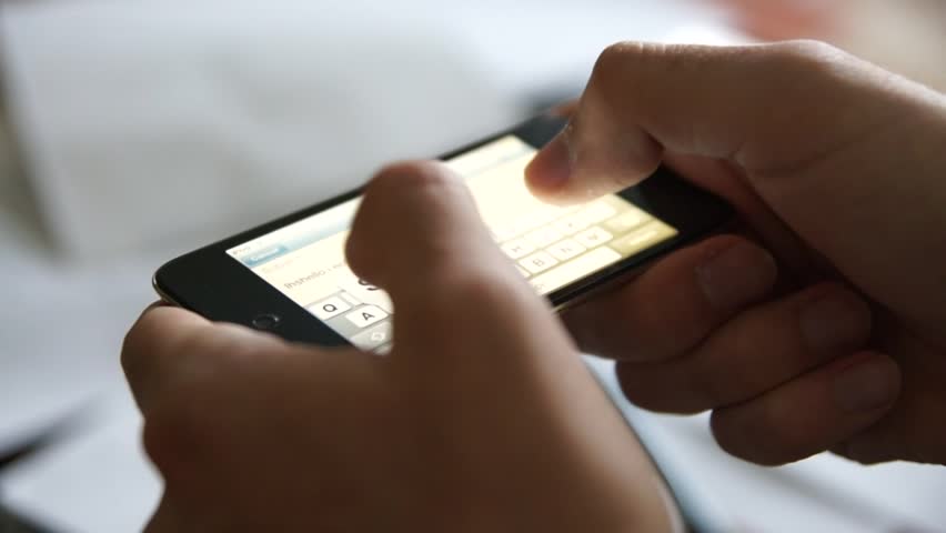 Male hands texting or typing on a touchscreen smartphone. Horizontal