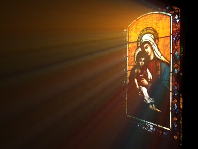 rays shine through stained glass with Mary and Jesus