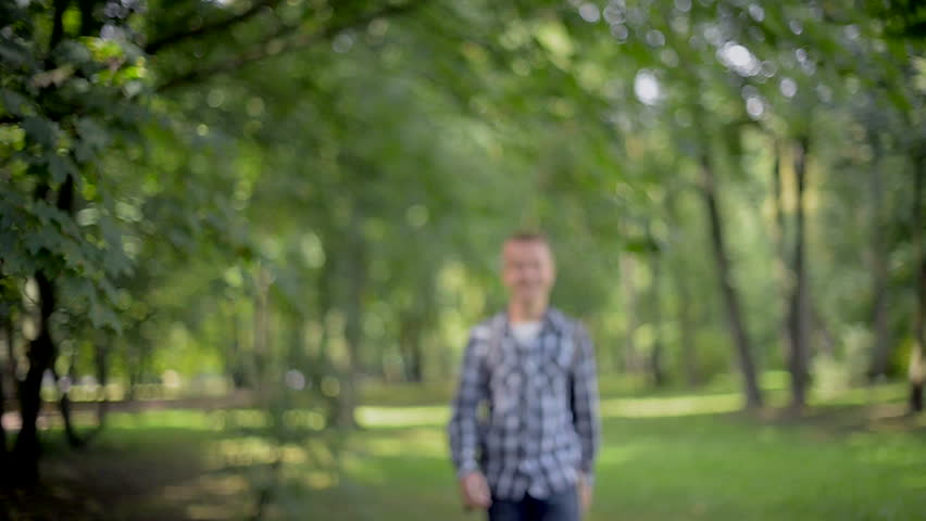 Student in campus park going on camera and smiling. 