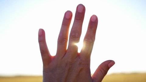 the sun's rays through the fingers of the hands