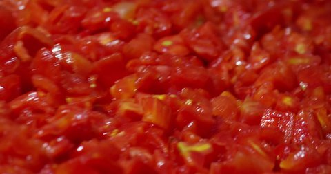 In an industry tomatoes, red tomatoes after being washed in the water are chopped into cubes to be packaged.I diced tomatoes traveling on the conveyor belt concept of nature, tomato bio-industry