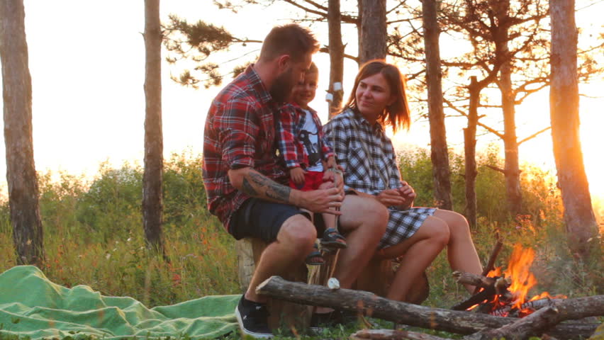 Young family outdoors to cook over a campfire marshmallows