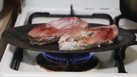 Fish meat being cooked on a grilling plate and moved by Spatula.
