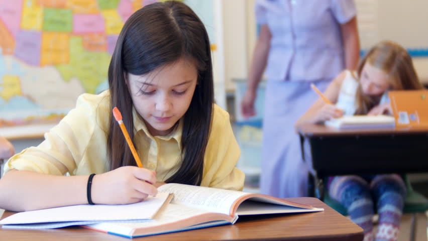 She is at school. Суд за партой. She is writing. Look she homework at School..