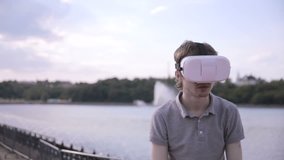 Young handsome man wearing virtual reality goggles in a city.
