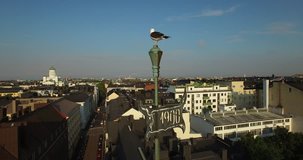Drone aerial close-up video of Baltic Seagull, vane on old building with Helsinki old town skyline on the background