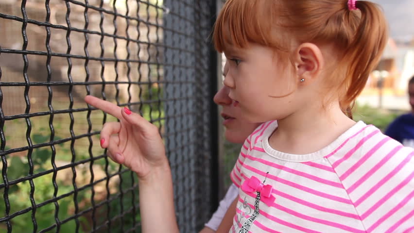 Mom and daughter watching the animals at the zoo