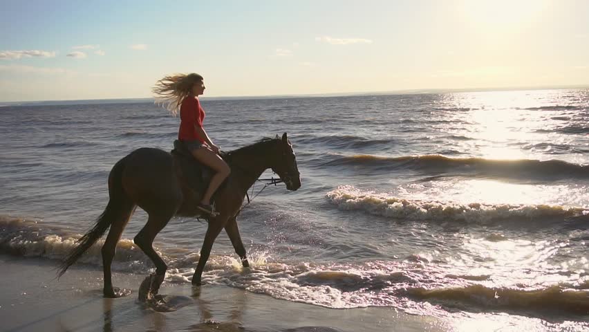 Golden-Haired beauty riding at the beach