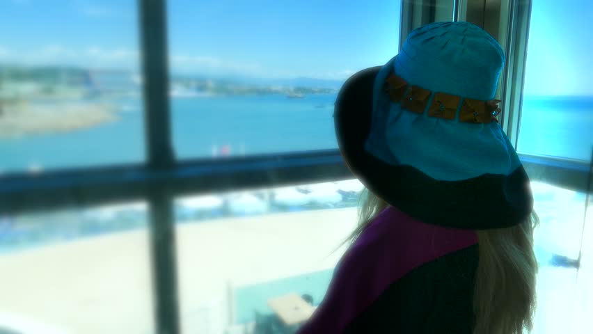 Caucasian Lady tourist woman female in the glass lift, elevator on the sea beach