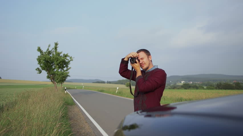 Young man photographing nature on mirrorless camera