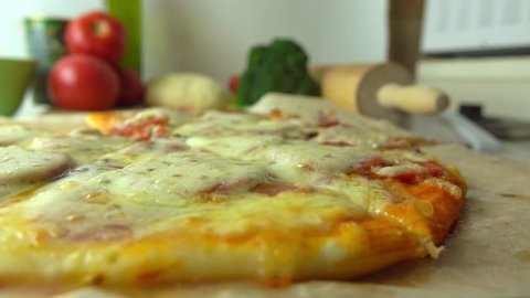 Cooking, part of the set. Taking a piece of freshly baked homemade pizza with stretching cheese. 4K close up video