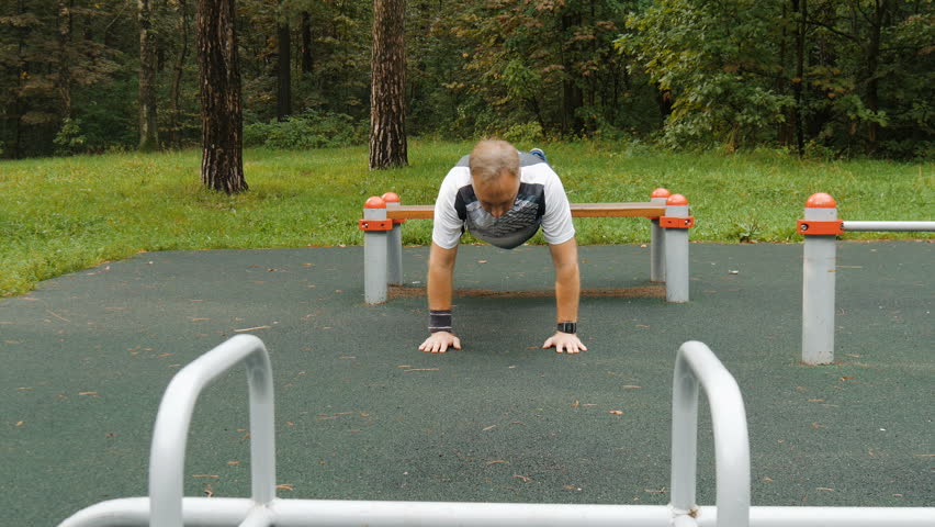 A man is exercising at an open pitch