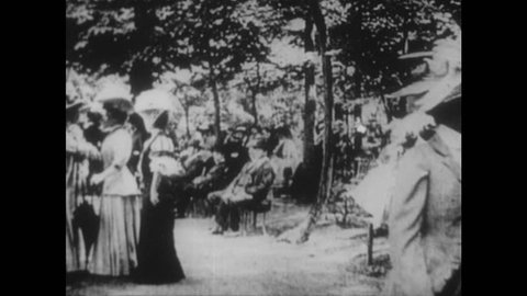 IUNITED STATES 1900s: Intertitle / People walking in park / Intertitle / Car drives through crowd / Sarah Bernhardt in car.