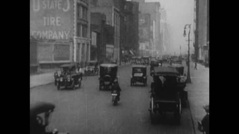 UNITED STATES 1900s: Intertitle / View of city street / Pedestrians, traffic in intersection.