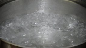 Boiling water in a kitchen pot as a symbol of cooking or food preparation and sterilization of contaminated tap water for healthy pure drinking liquid.