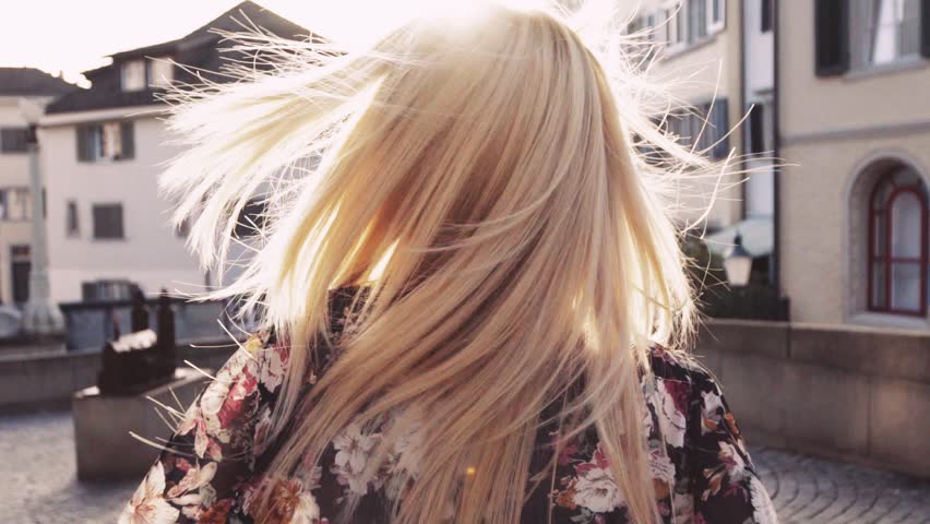Young blonde girl is wondering down the Italian streets. Cute smile. Summer, sun is shining, Italian evening, sunset. No people around, female portrait. Slow motion, close up view, stabilizer shots.
