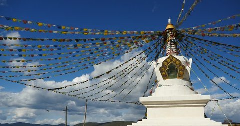 4k buddhist white stupa & flying prayer flags with blue sky background,shangrila yunnan,china. gh2_10474_4k
