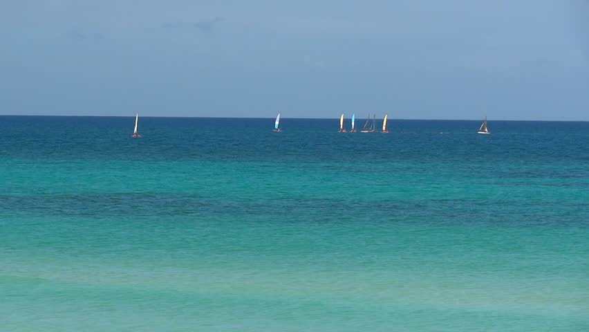 Small windboats sailing on the caribbean coast. Beautiful water color.