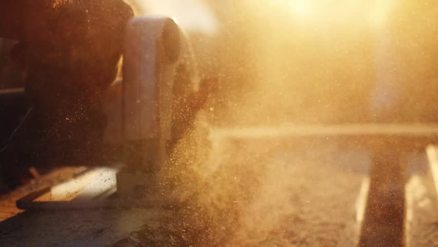 Man is craft working at a work bench with power tools in slowmotion during sunset with beautiful lens flare. 1920x1080 | Shutterstock HD Video #19061482
