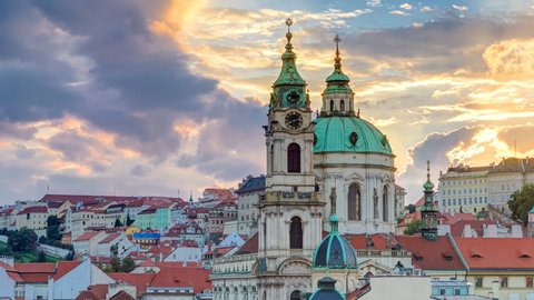 sunset behind St Nicolas timelapse in Mala Strana in Prague. Colorful cloudy sky. View from Lesser Town Tower