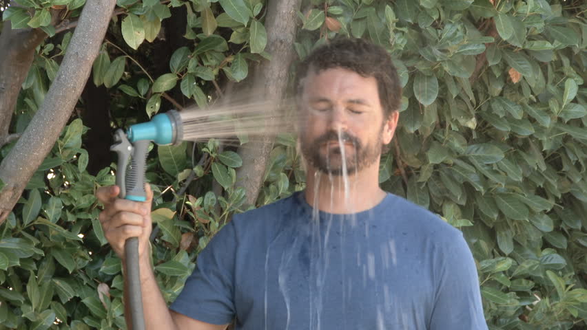 Slow motion of model released man spraying himself in the face with a hose outside on a hot summer's day. Royalty-Free Stock Footage #19070077