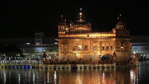 AMRITSAR, INDIA - SEPTEMBER 28, 2014: Unidentified sikhs and indian people visiting the Golden Temple in Amritsar at night. Sikh pilgrims travel from all over India to pray at this holy site.