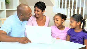Young african american family using a laptop to talk with family and friends via internet web chat